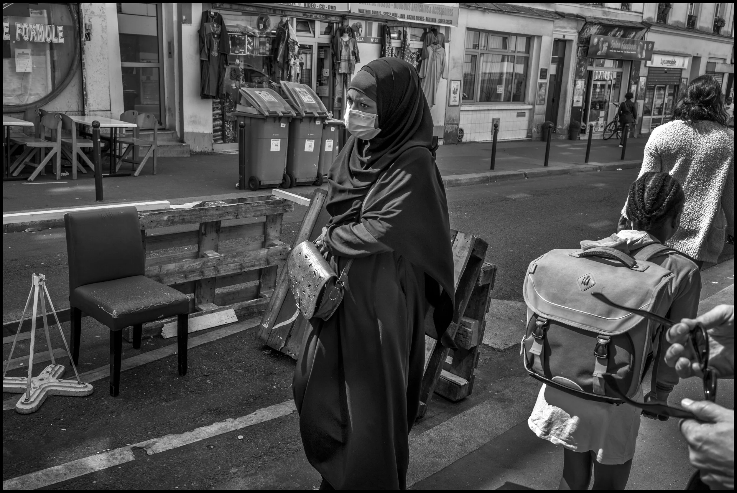  A woman walks past a formal men’s wear shop on Boulevard Magenta, Paris.  June 29, 2020. © Peter Turnley.   ID# P47-003 