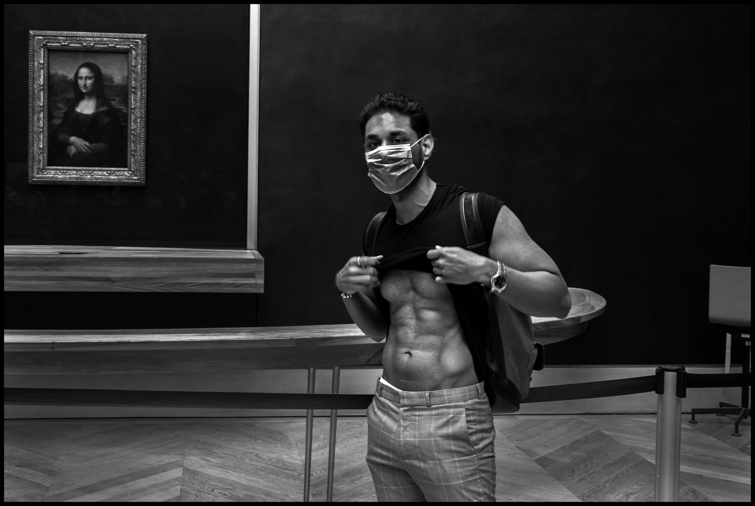  A young man exhibits his own personal art work in front of the Mona Lisa at Le Louvre. July 6, 2020. © Peter Turnley.  ID# P55-004 
