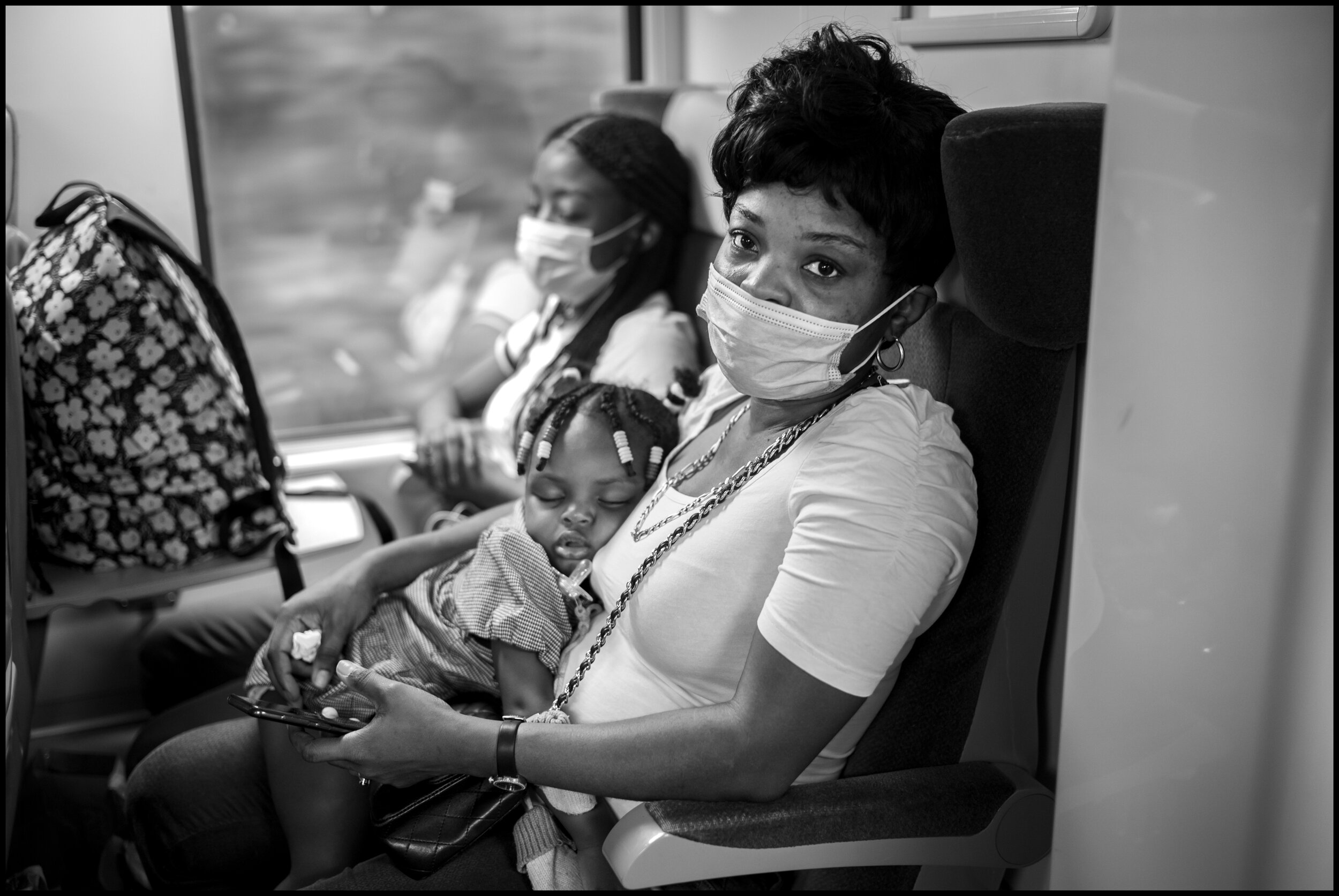  A mother, Childa, with her daughter, Victoria, on the train to Paris. July 11, 2020. © Peter Turnley.  ID# P59-009 