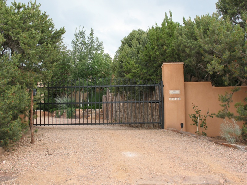  Automatic access system controlling wrought iron gate, with wall and coyote fence 