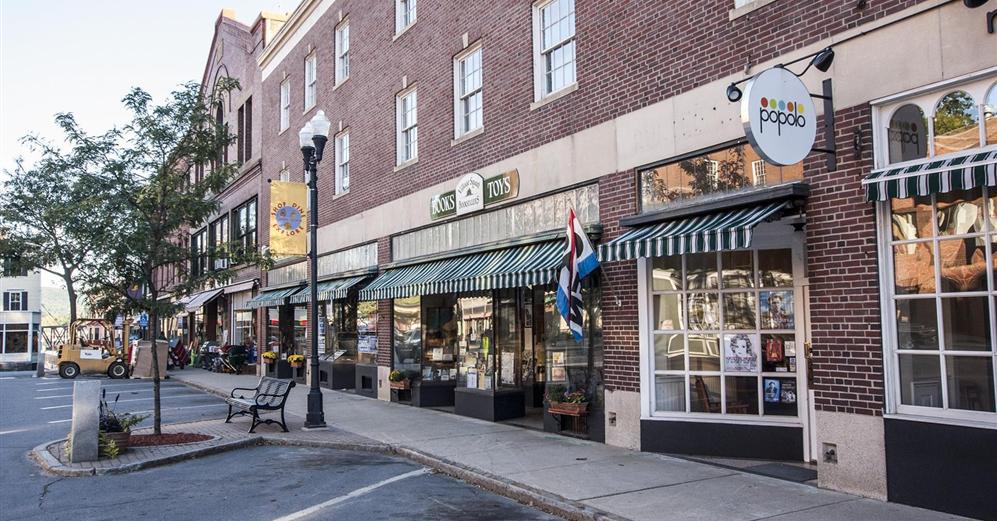 The Hotel Windham at street level with three store fronts, a restaurant, hotel lobby, ballroom, sunporch and rear deck overlooking the oldest river canal in the United States.