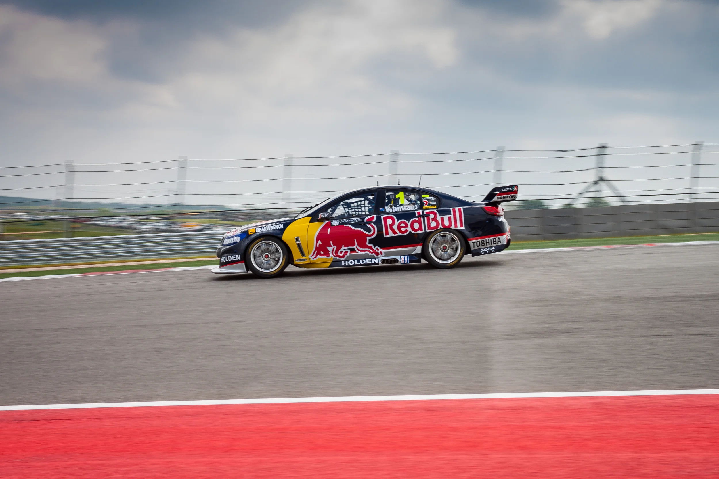 Points leader Jamie Whincup in the Red Bull Racing Australia #1 car puts the hammer down out of turn 1 at Circuit of the Americas Race Track in Austin, Texas.