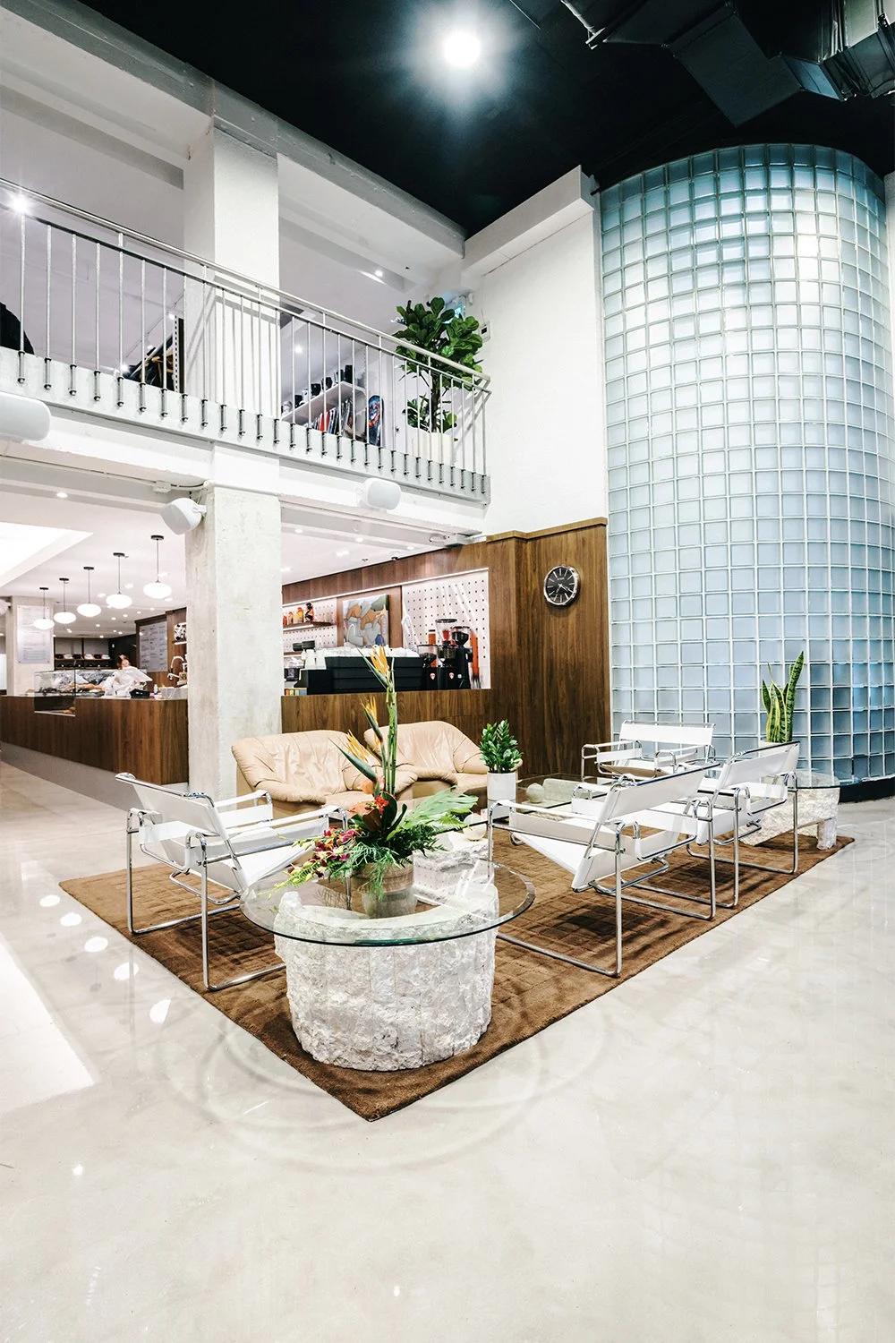 Empire café lounge designed by Finkel' featuring seating and a sculptural glass block column within a double-height hospitality space