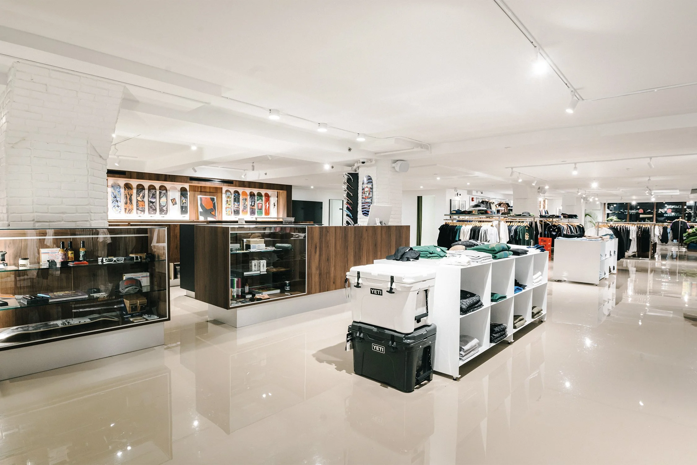 Bright retail interior with custom wood display counters, glass vitrines, and modular merchandising designed by Finkel' for the Empire flagship store