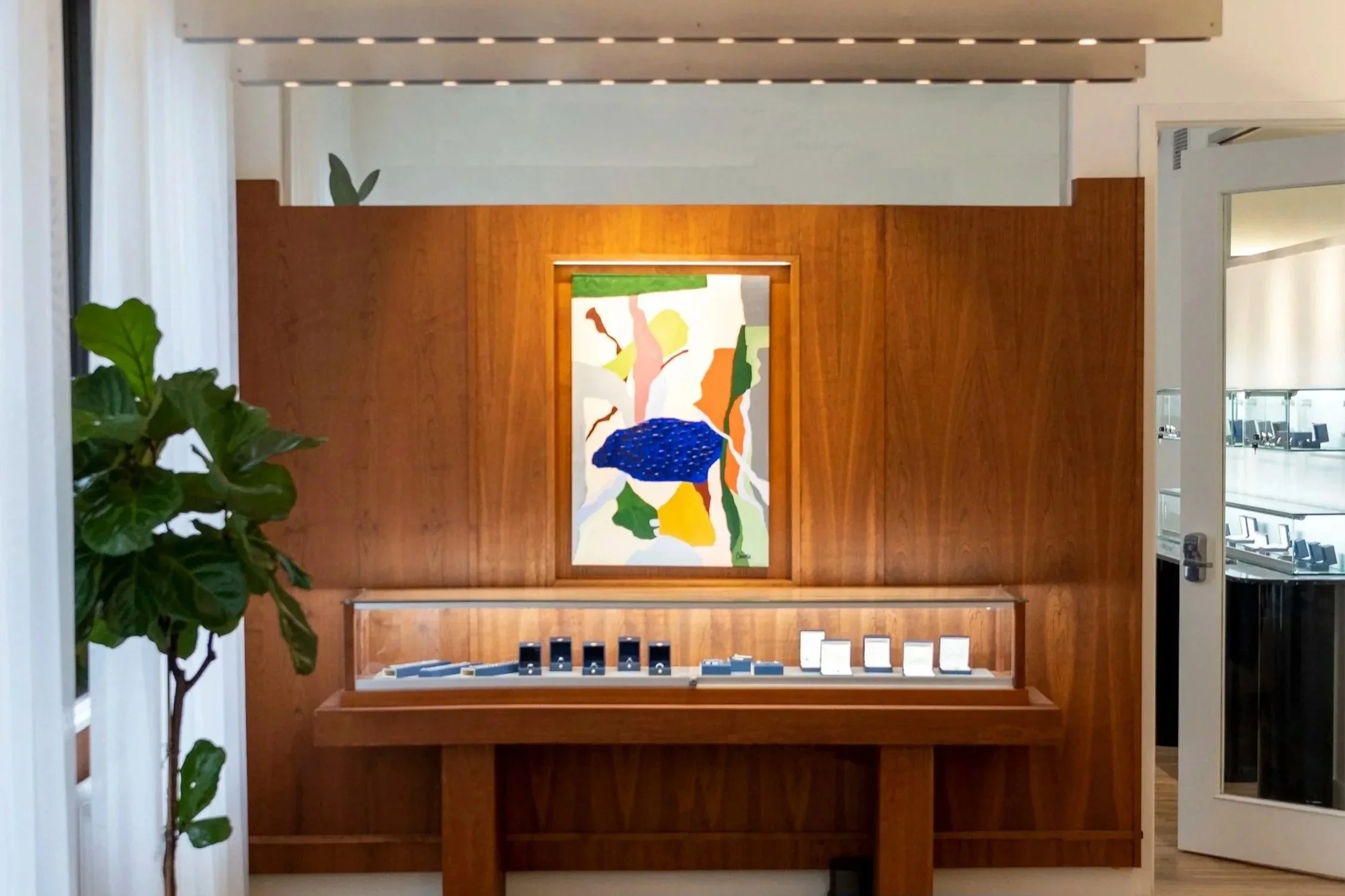 High-end showroom interior design featuring custom wood display cabinet and integrated lighting