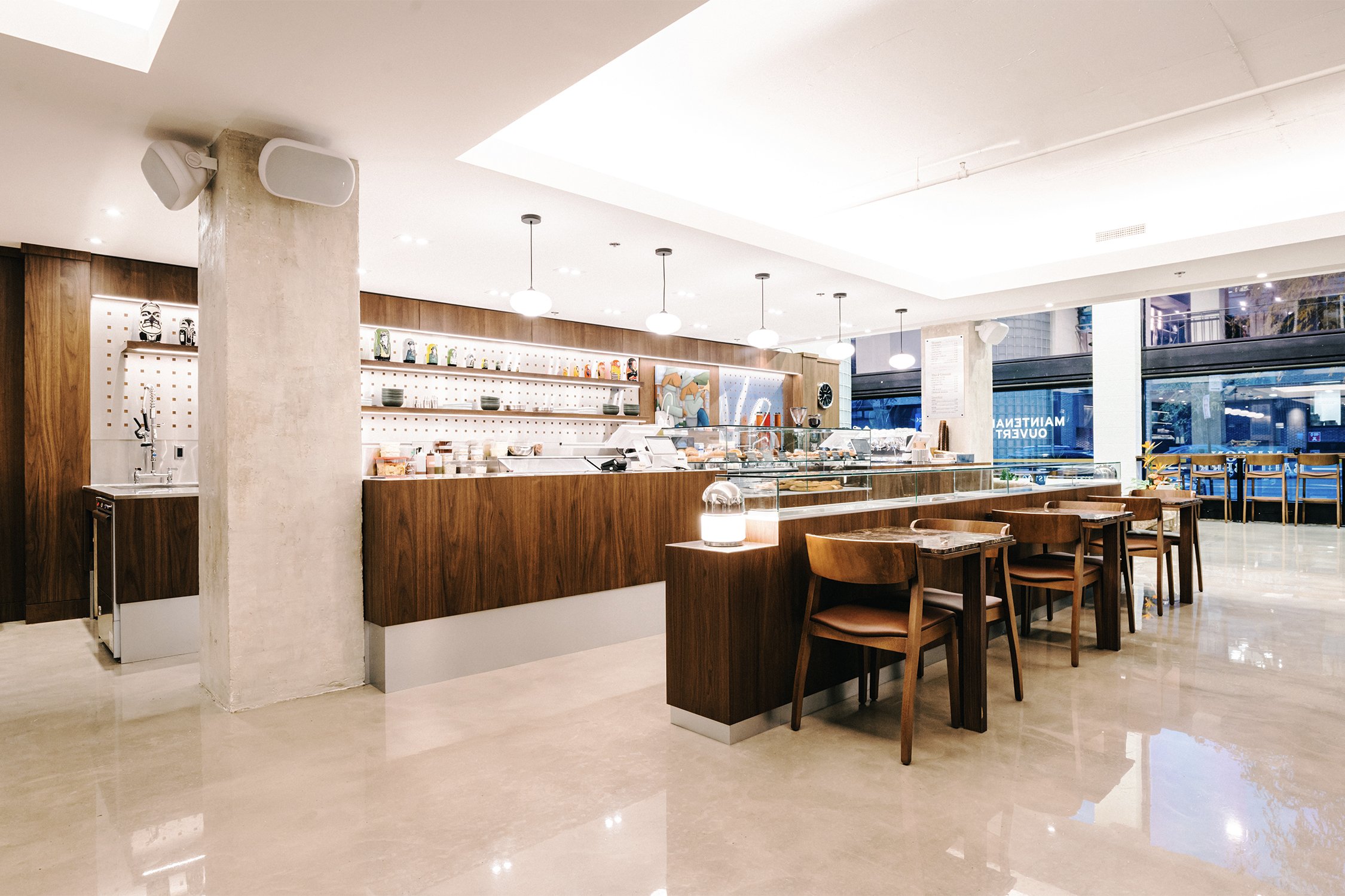 Café interior designed by Finkel for Empire, featuring custom wood millwork, integrated seating, and a warm modern hospitality space