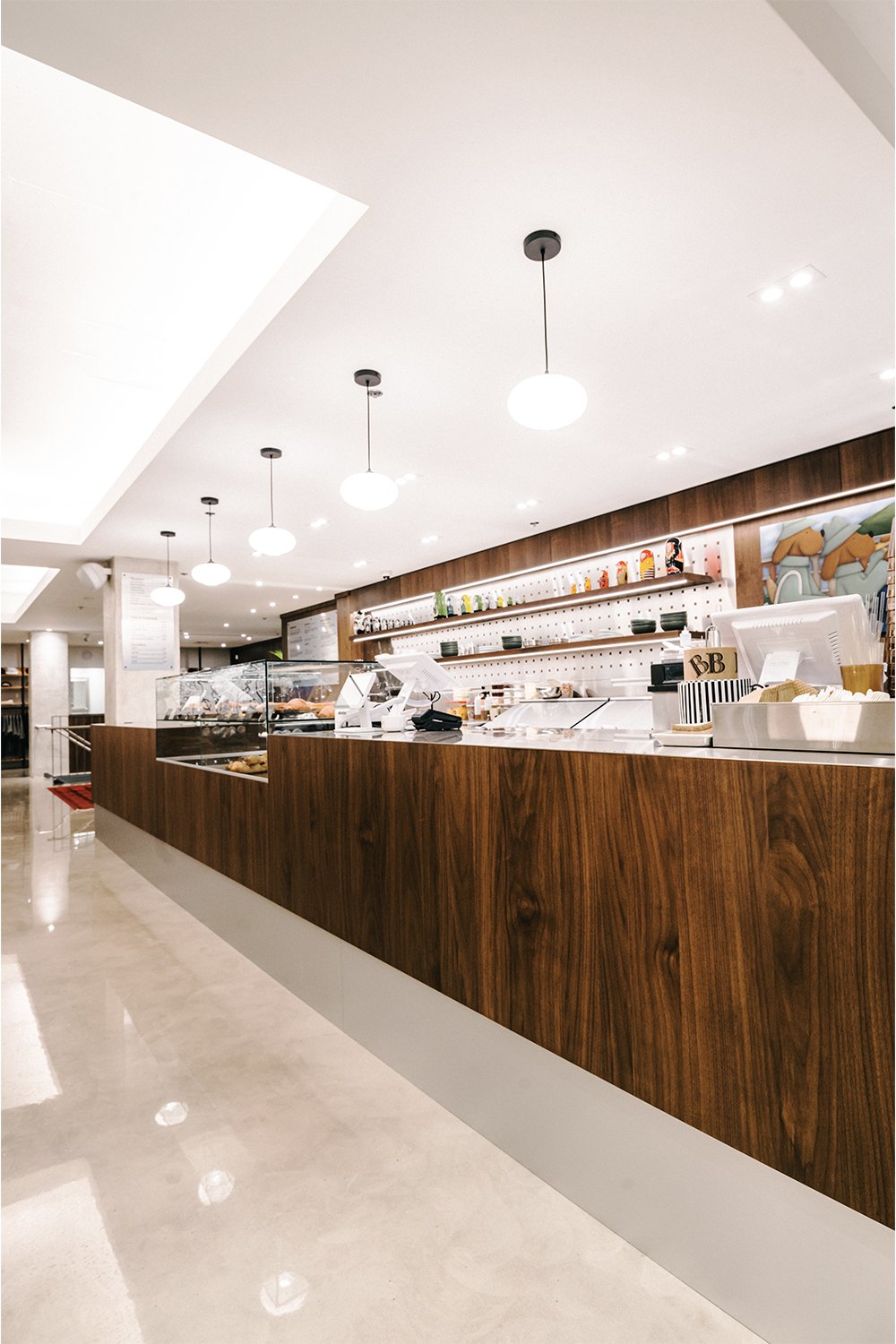 Custom café service counter designed by Finkel for Empire, featuring wood millwork and a clean modern hospitality layout