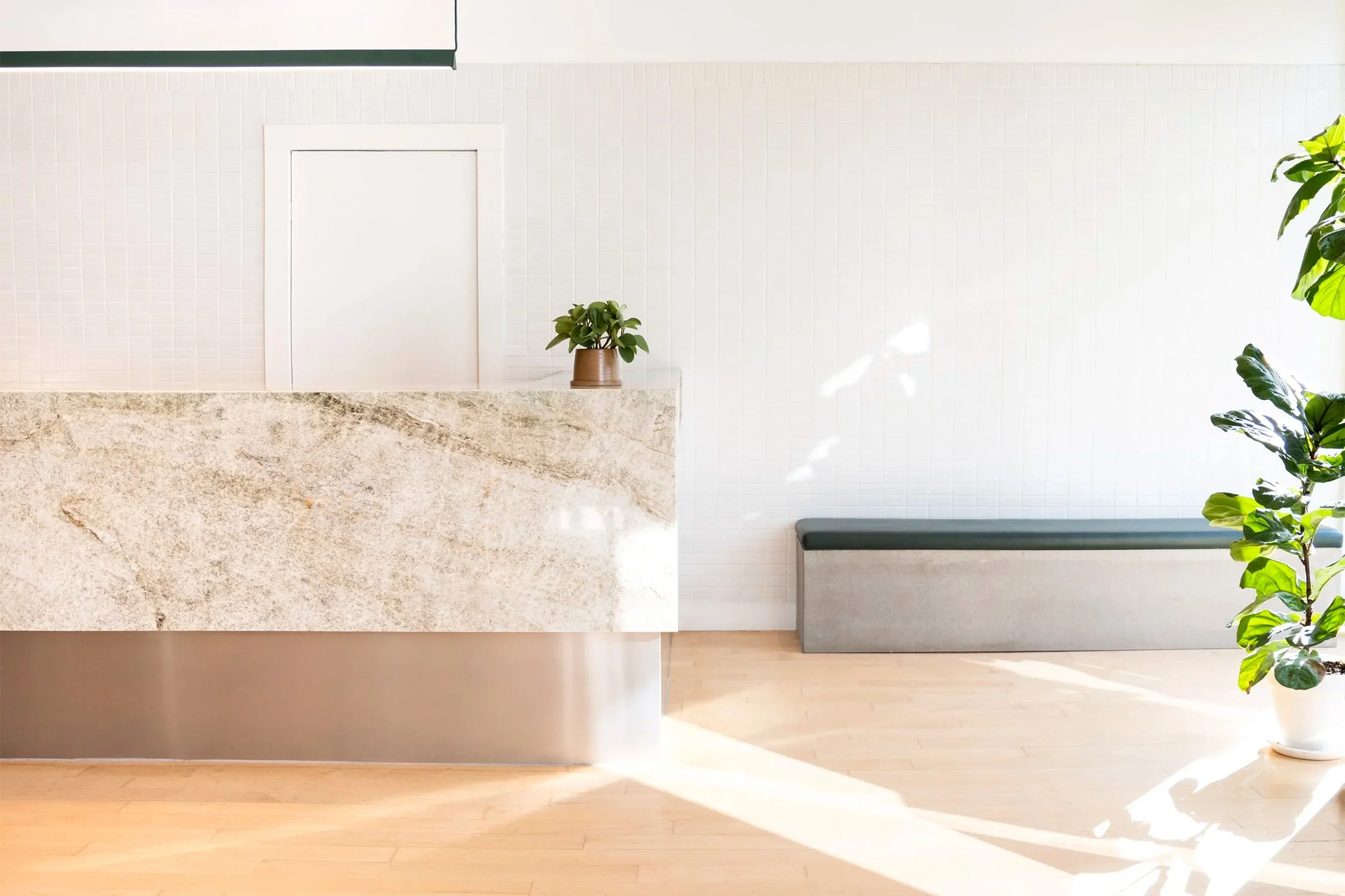 Custom stone retail counter designed by Finkel for Archive, featuring integrated bench seating and minimalist interior