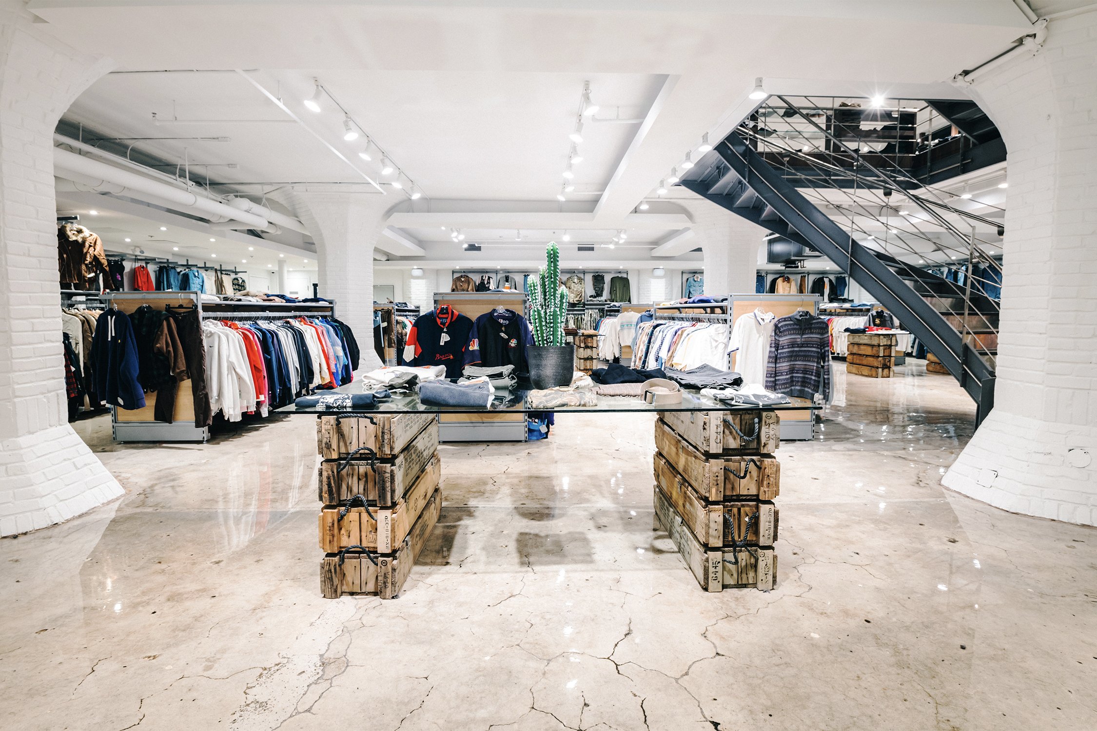 Central retail aisle with merchandising tables and staircase designed by Finkel, for Empire’s flagship store