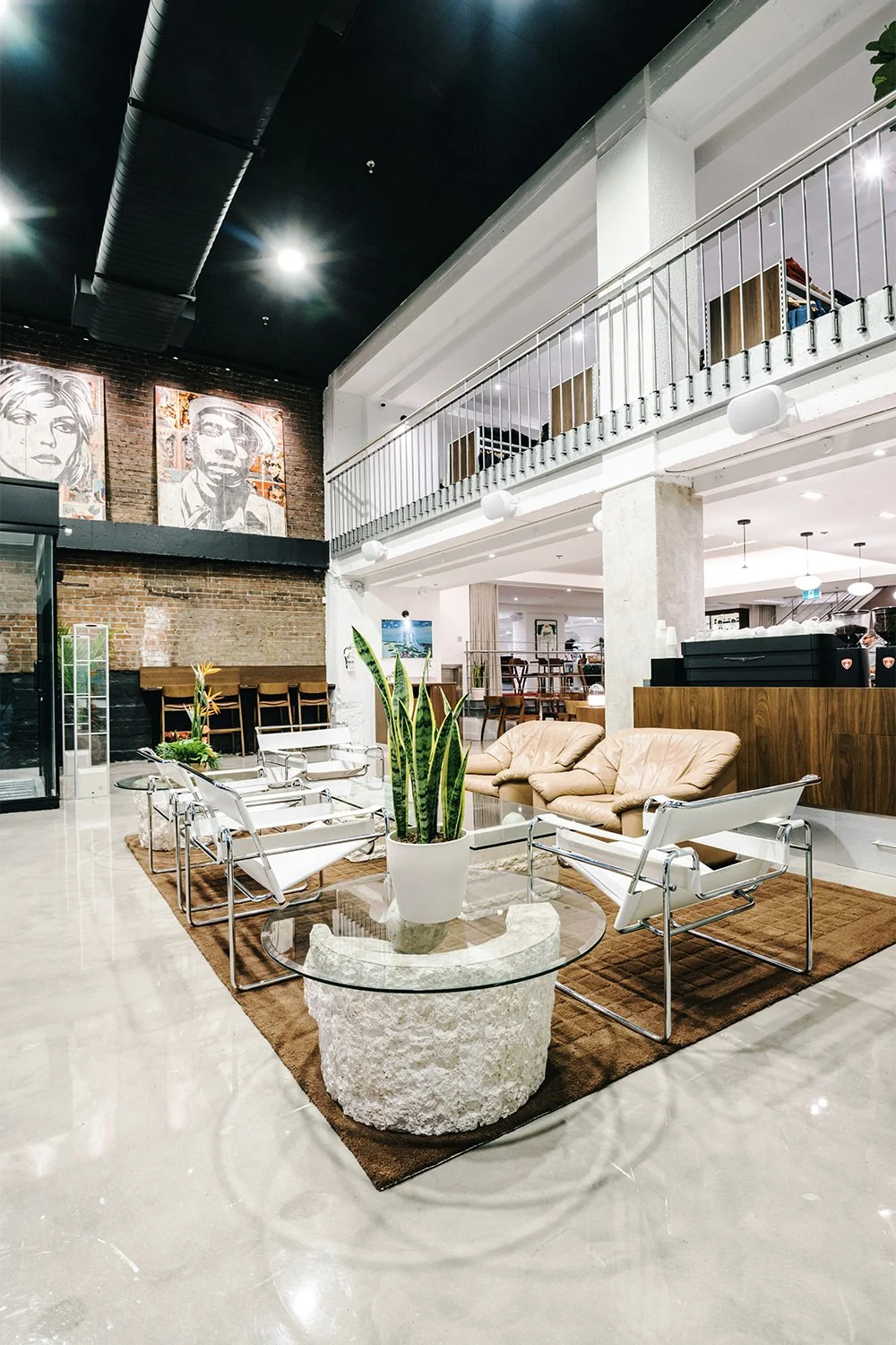 Empire café lounge designed by Finkel' featuring seating, stone tables, and a double-height hospitality interior