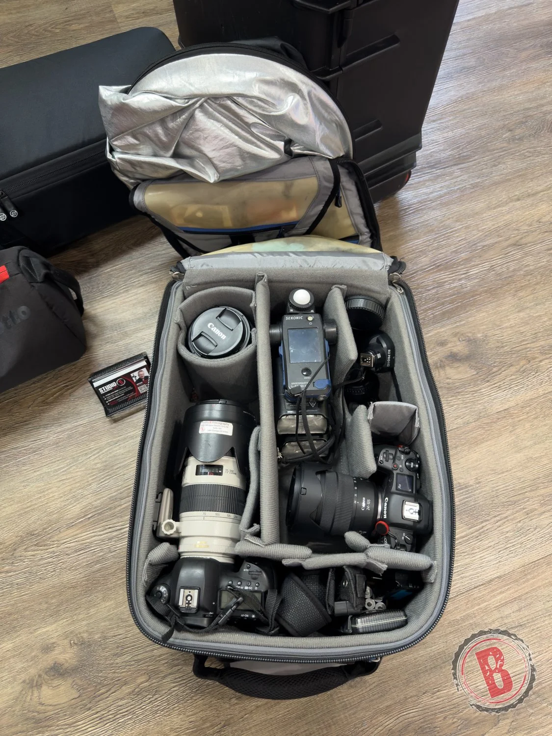 Professional camera bodies, lenses, light meter, and backup gear prepared for corporate headshots on location.