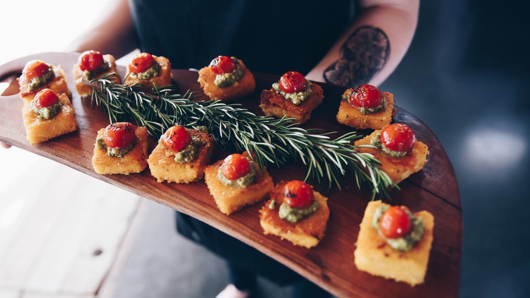 Grilled polenta with fresh basil pesto and blistered tomatoes.