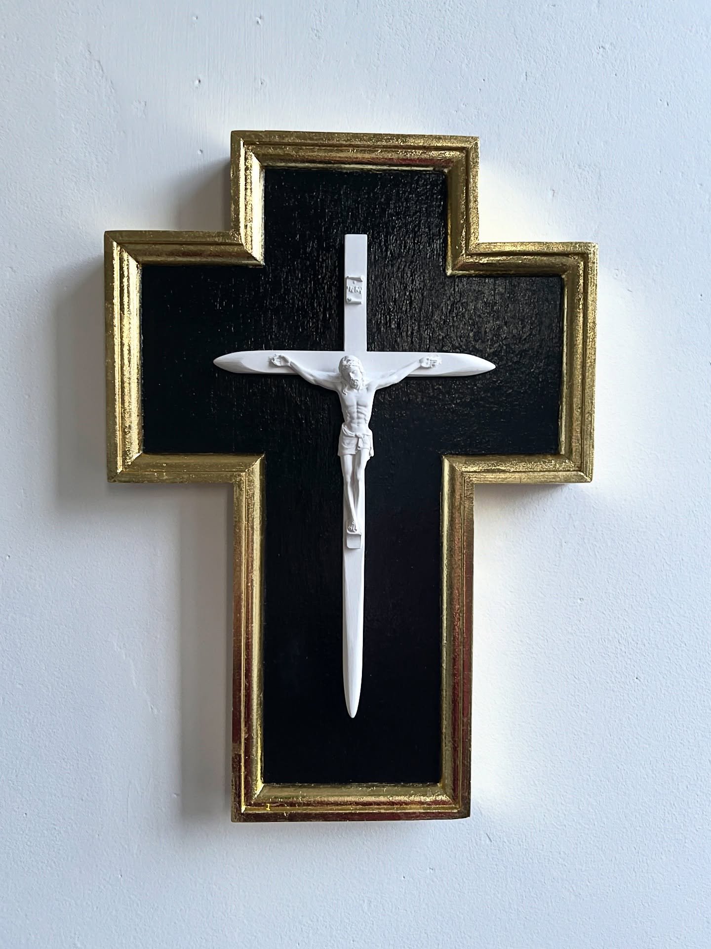 PHARMAKON Wood, Plaster, Gold leaf, Black paint, Varnish.
34 X 24 X 5.5cm 
2025

PHARMAKON explores the paradoxical nature of sacred objects and their power. The crucifix is reconfigured as an instrument of defence, sanded to points like a stake occu