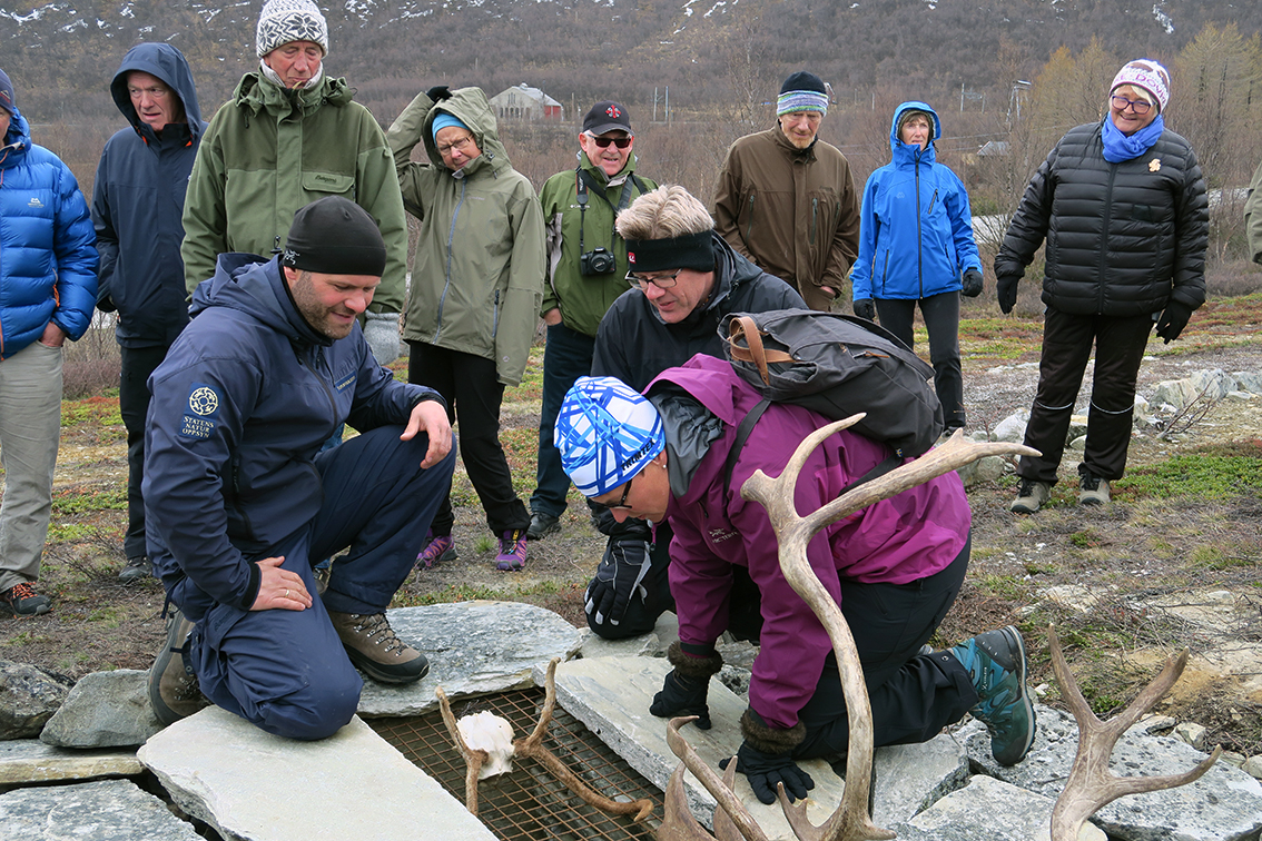Klima- og miljøminister Tine Sundtoft sjekker en av de rekonstruerte fangstgropene for villrein. Dyktig informant er SNOs Espen Rusten (til venstre). Foto: A. Nyaas