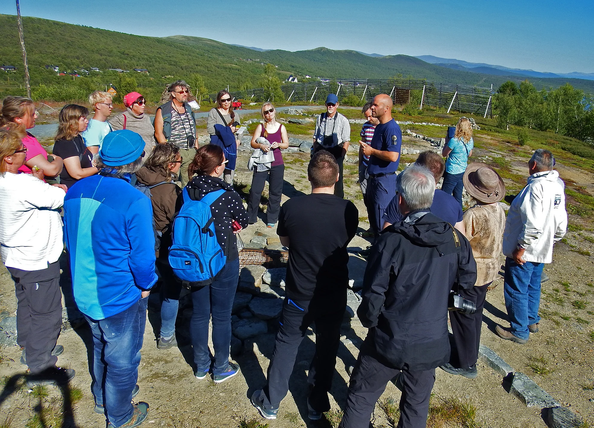 Naturveileder Espen Rusten ved Norsk Villreinsenter Nord på Hjerkinn forteller med stor innlevelse om gamle fangstgraver. Foto: Tor Punsvik