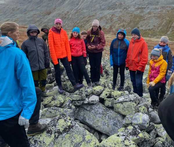 Naturrettleiar Kristin Gansmo Brenna (t.v.) har samla elevane rundt eit bogestille i Illmanndalen. Foto: Kjell Bitustøyl