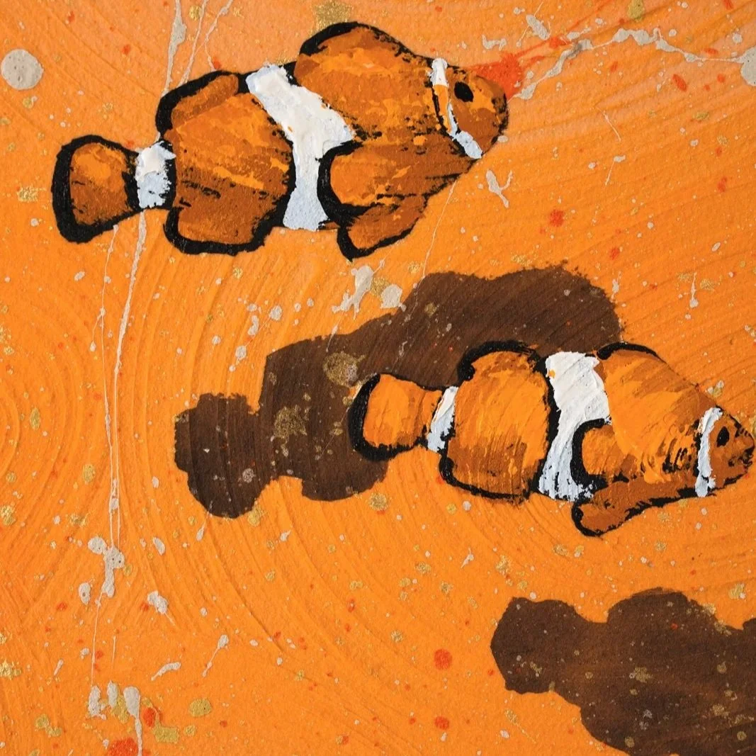 A cropped image of two clown fish floating through space against a vibrant orange background by New York City based painter Josh Brown.