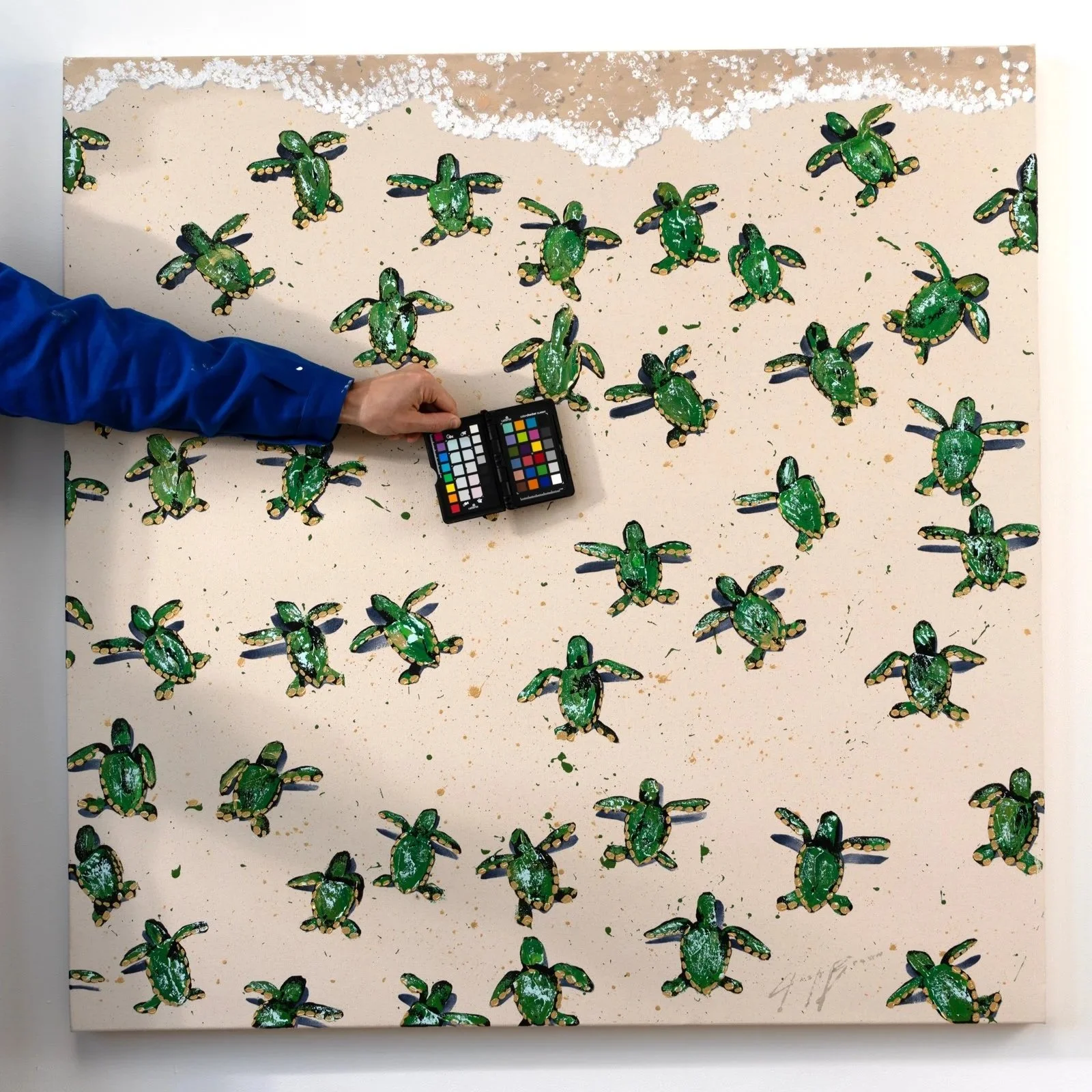 Minimalist coastal painting with stylized green turtles arranged in a rhythmic pattern with the artist and a color checker by New York City based painter Josh Brown.