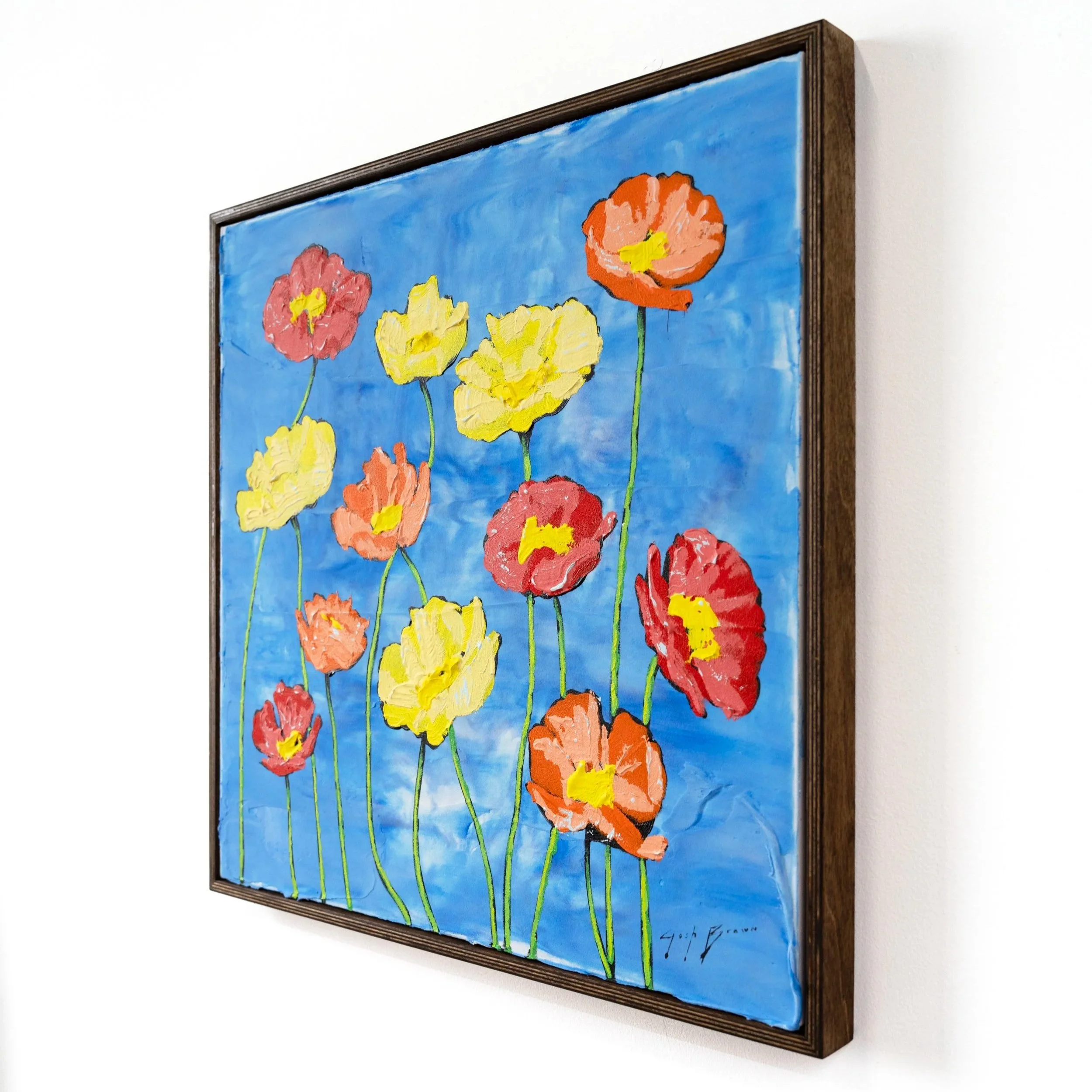 Framed contemporary floral painting with red, yellow, and orange flowers against a vivid blue background by Josh Brown.
