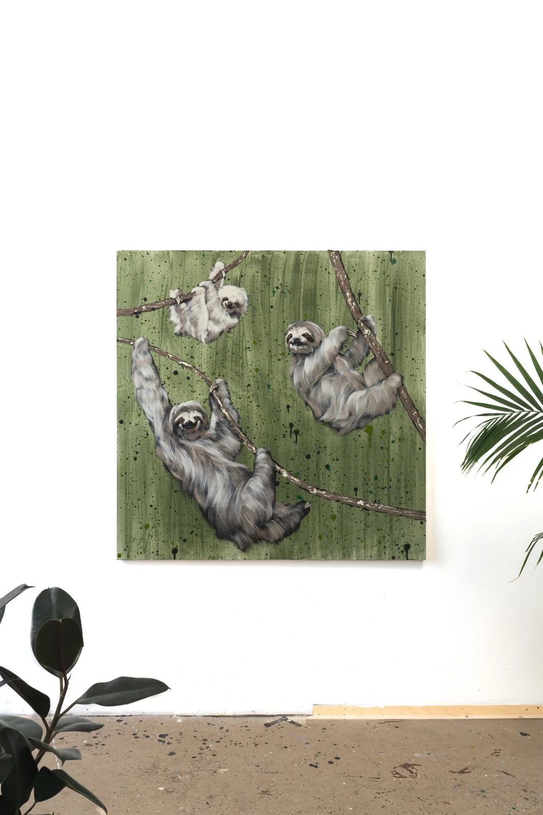 An image of hand-painted sloths gripping a tree branch, showing soft fur texture and expressive eyes against a green, splattered background by Josh Brown.