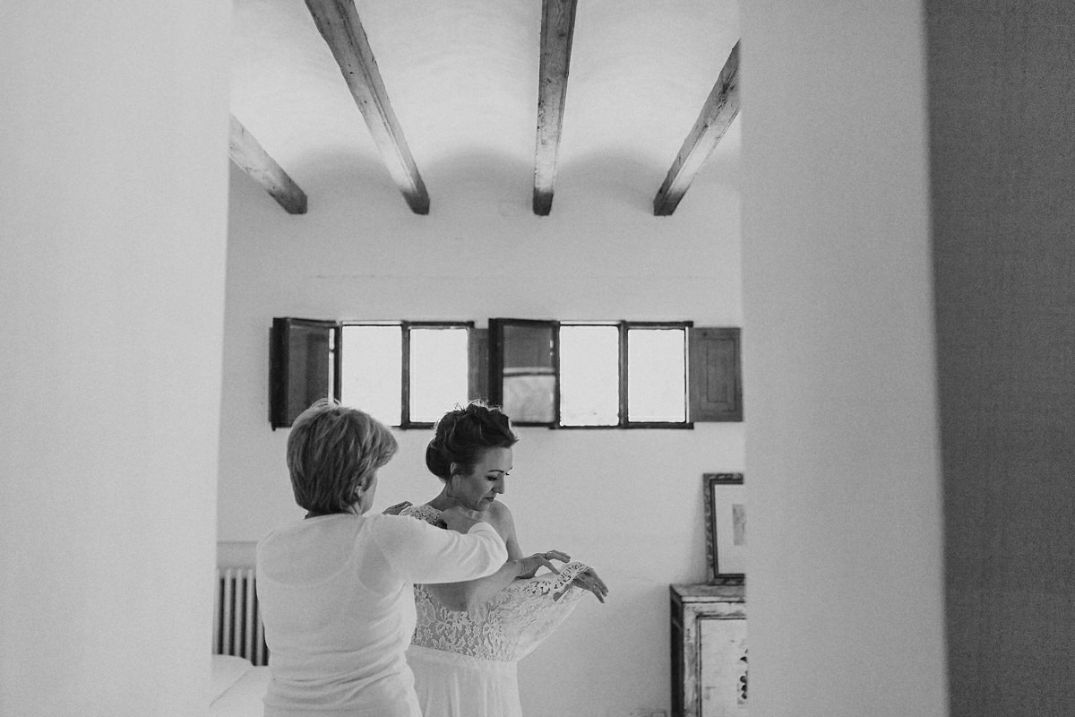 Bride having her dress put on