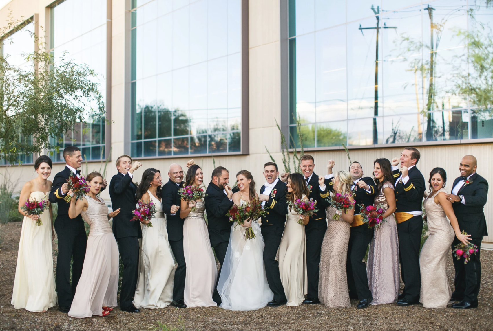 Full wedding party lined up outside a modern venue for a full day wedding photography package