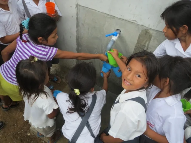 Children drink filtered water for the first time in the remote jungle village of Auca Cocha near the Amazon River in Peru.