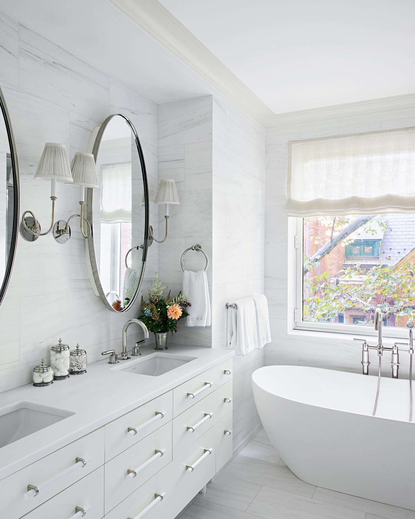 A serene primary bathroom in Chelsea.  Featuring custom oval medicine cabinets, @urbanelectricco Loopy sconces, @waterworks fixtures and honed dolomite tile from floor to ceiling
📸: @brittanyambridge
