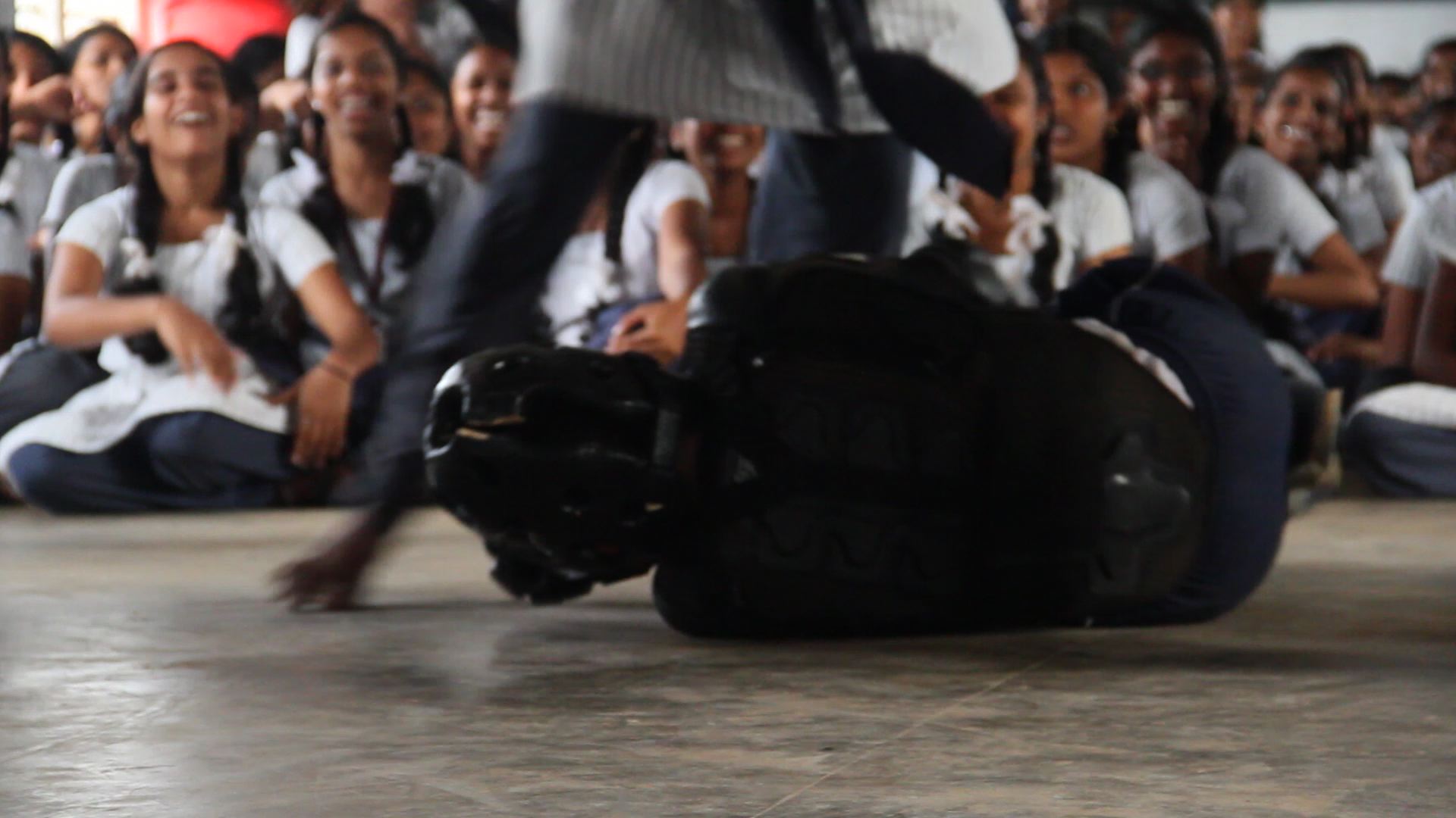 Girl kicking a trainer on the floor during an attack
