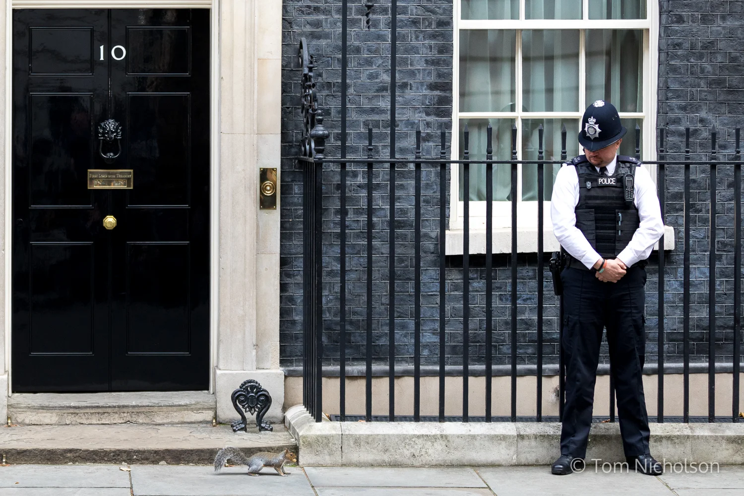 ©2017 Tom Nicholson. 26/09/2017. London, UK. A policeman looks as a squirrel runs past No 10 Downing Street.