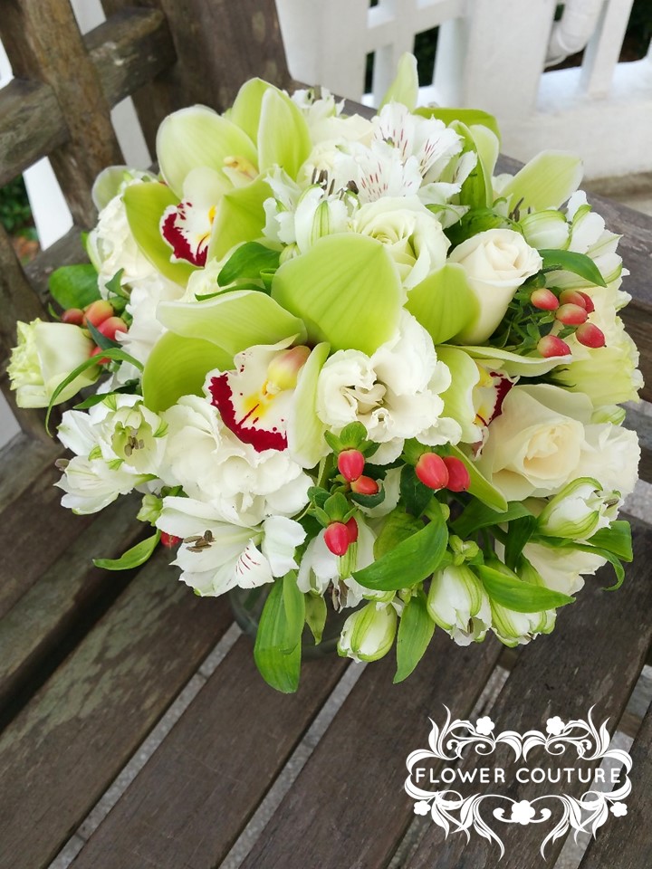 Green cymbidium orchids, white alstro, cream roses, white eustoma, red hypericum.