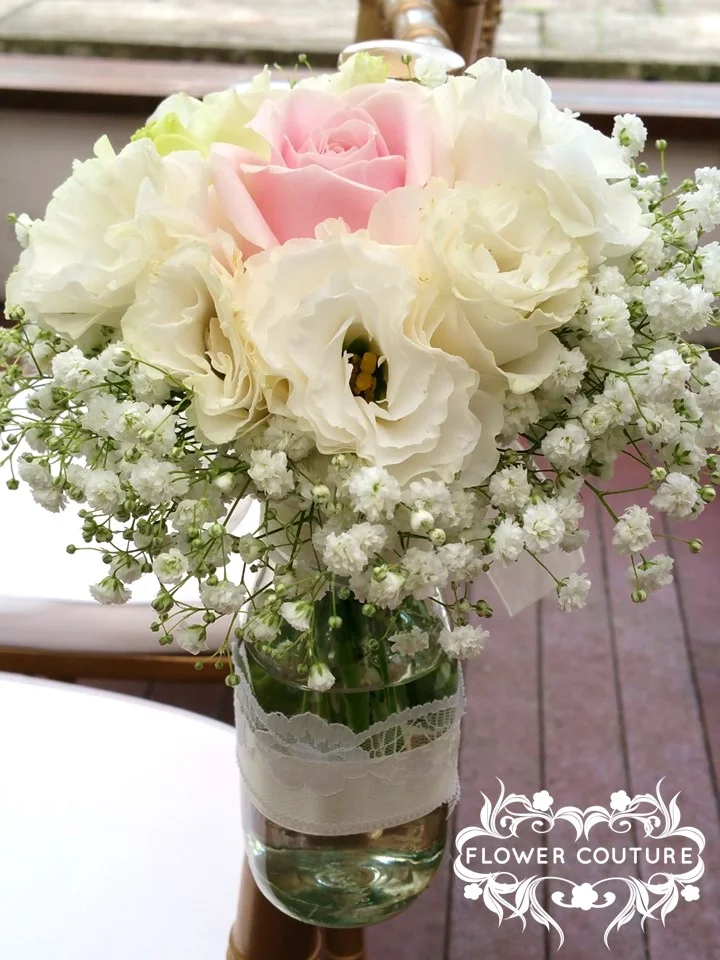Flowers in bottles for march-in-aisle chairs