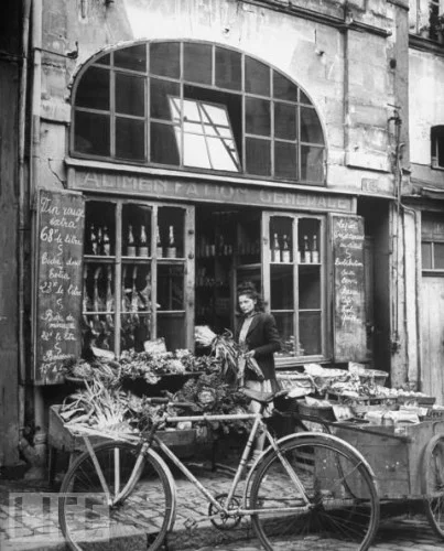 jenclone:

eachdayaflower:

A woman buys produce at a neighborhood market in France. 1949. (via)