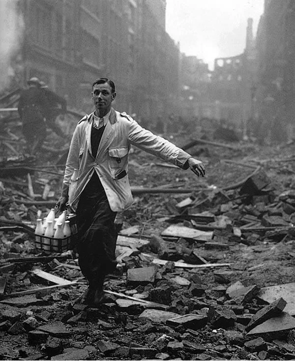 my-ear-trumpet:

parachuteshark:

A milkman delivering milk in a London street devastated during a German bombing raid. Firemen are dampening down the ruins behind him. (ph. Fred Morley)