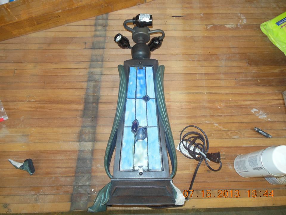 took in a Tiffany reproduction table lamp for replacement of art glass panes in the front panel and repairs to broken leg. Not rare or expensive but still in need or repair..jpg