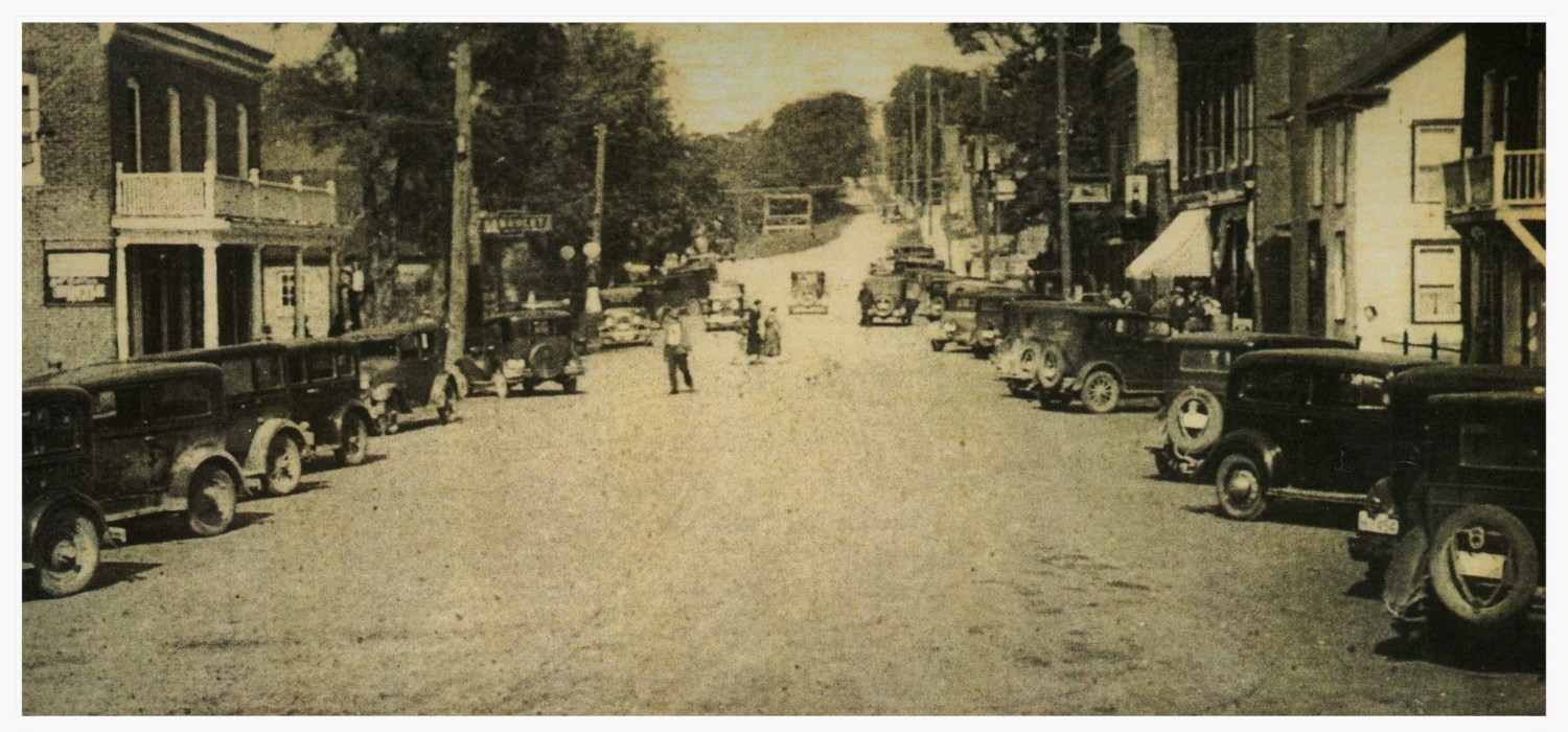Forsyth, looking north. In the 1930's Marmora was still known for the porches on the main street. The road was wider, the sidewalks narrower, and cars parked on an angle.