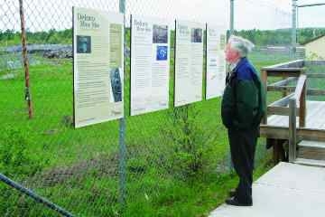 Judy Backus, Stirling EMC Doug Lynch, a longtime resident of Deloro and a member of the Deloro Mine Site Cleanup Public Liaison Committee since its inception in 1996, has a look at the descriptive sign boards installed at the mine site lookout located at the end of Private Road.