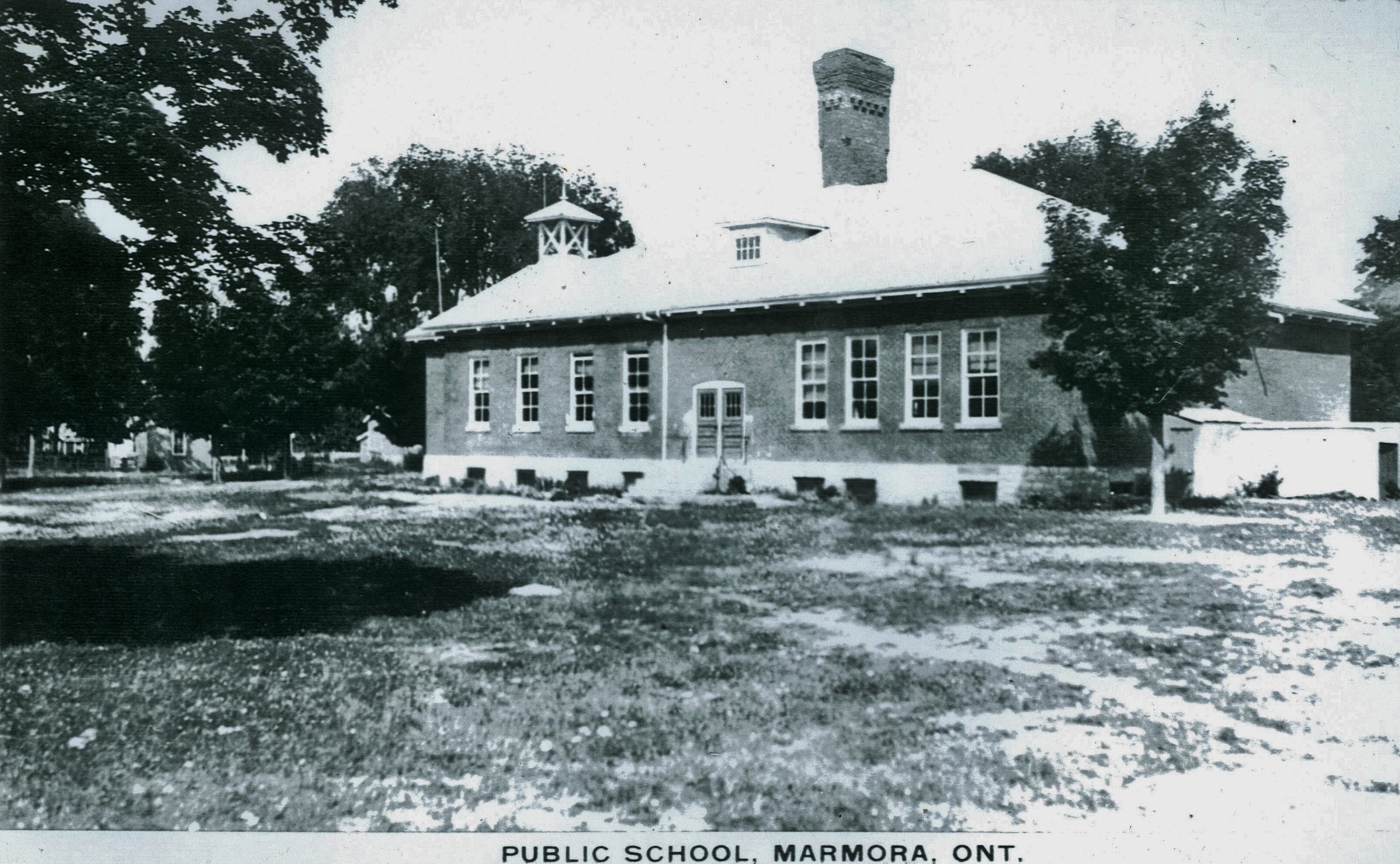 In 1915 the original structure (see above ) burned and this building was constructed from the remains of the first floor. Note school bell and large chimney. Photo taken before extension built.