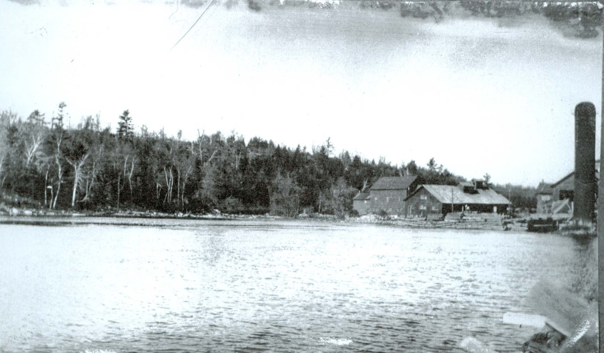 Photo of Pearce Mills constructed on what is now the dam location. Visible is the west shore of Crowe River.