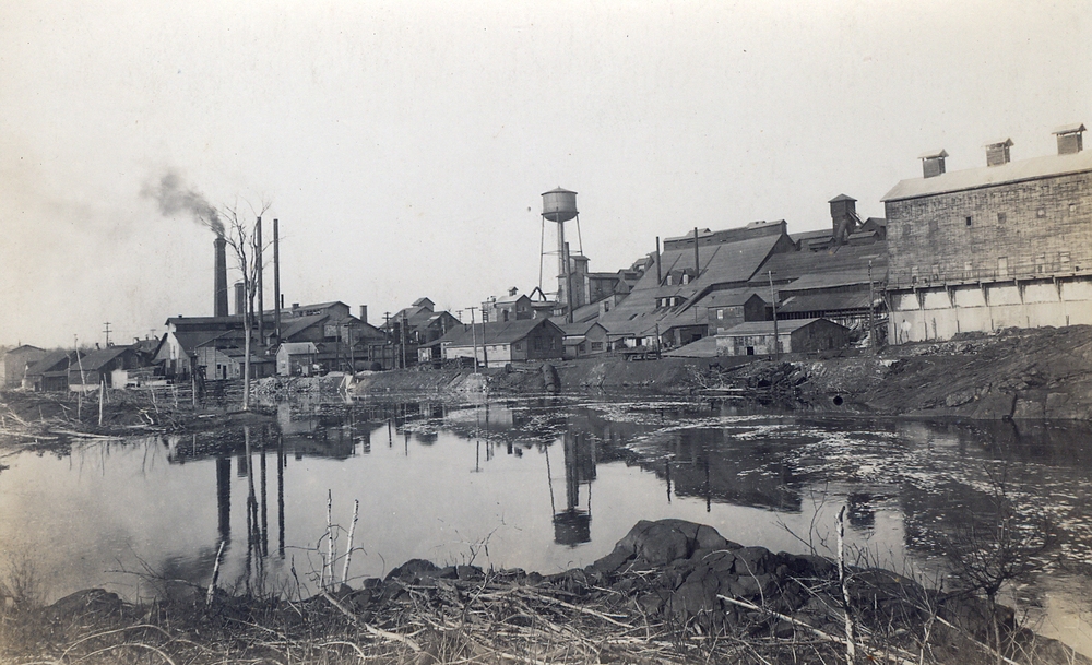 DELORO 1916 FROM THE EAST BANK OF RIVER. NOTE 1882 ARSENIC WORKS CENTRE STILL IN USE. ARSENIC BAG HOUSE ON RIGHT; COBALT OXIDES PLANT ON LEFT