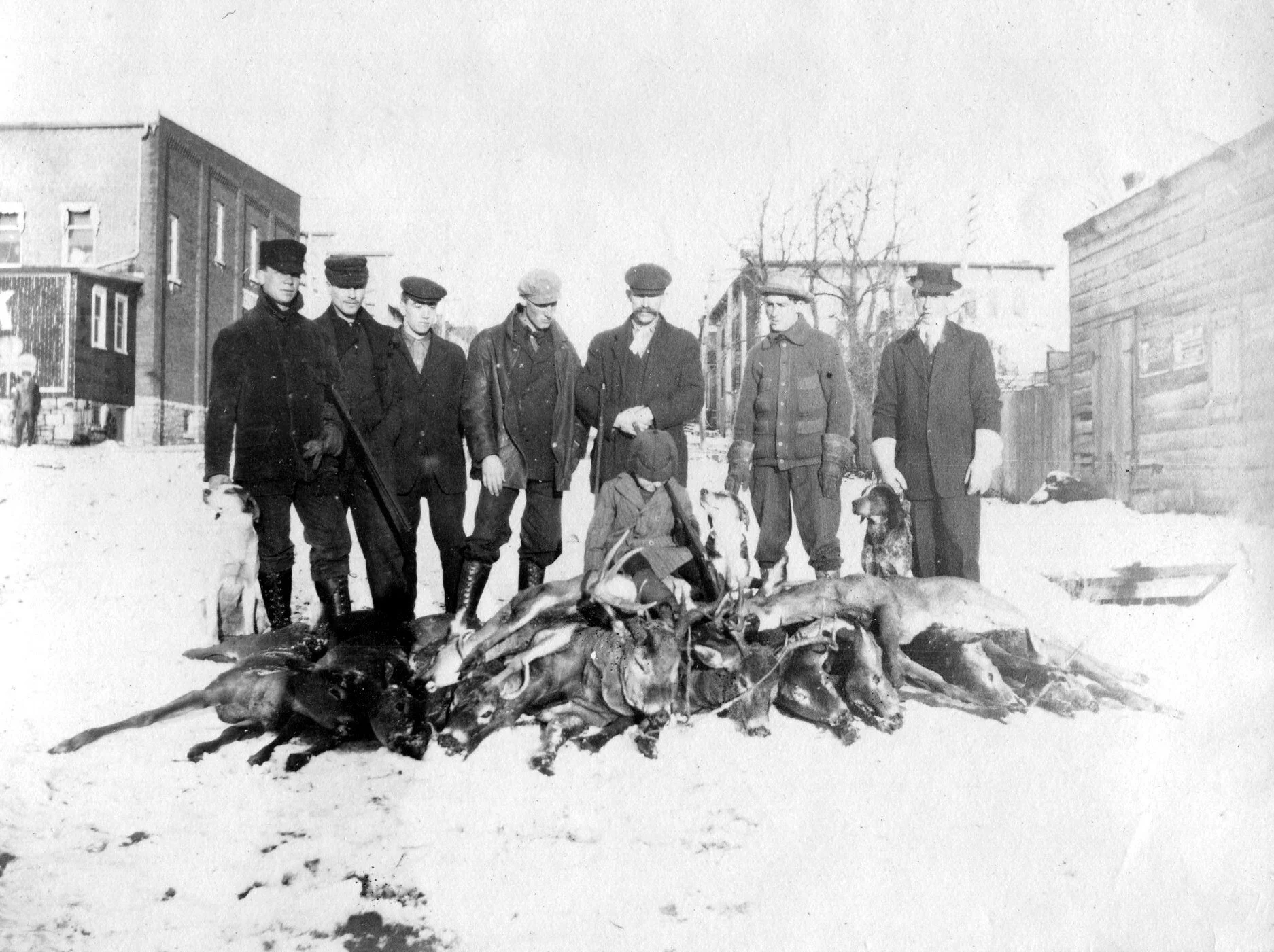 This photo, on the right, shows the original wooden structure that stood on the lot prior to Sweet’s building a red brick structure.