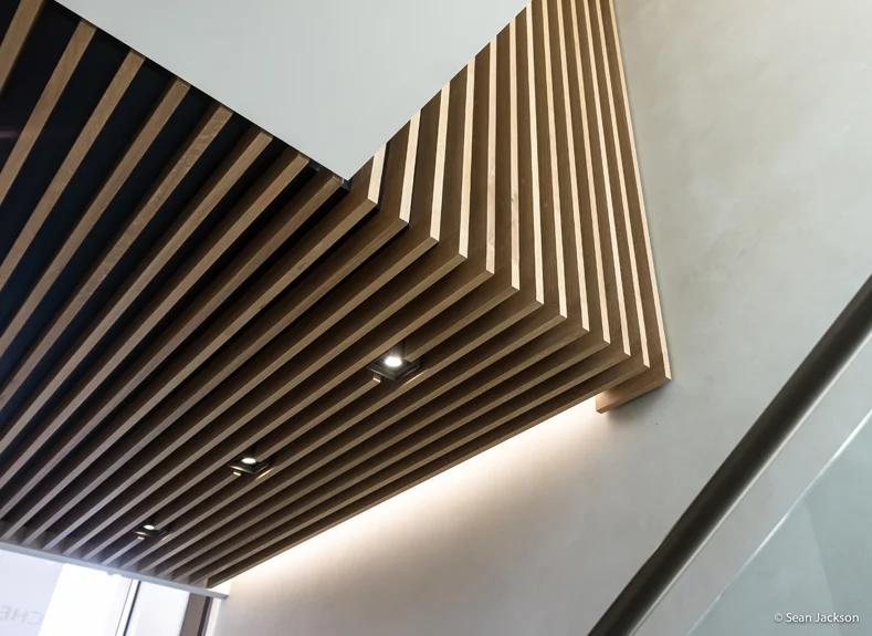  Oak timber slats wrap up the return wall above the stairs, visualy linking the double height space. 