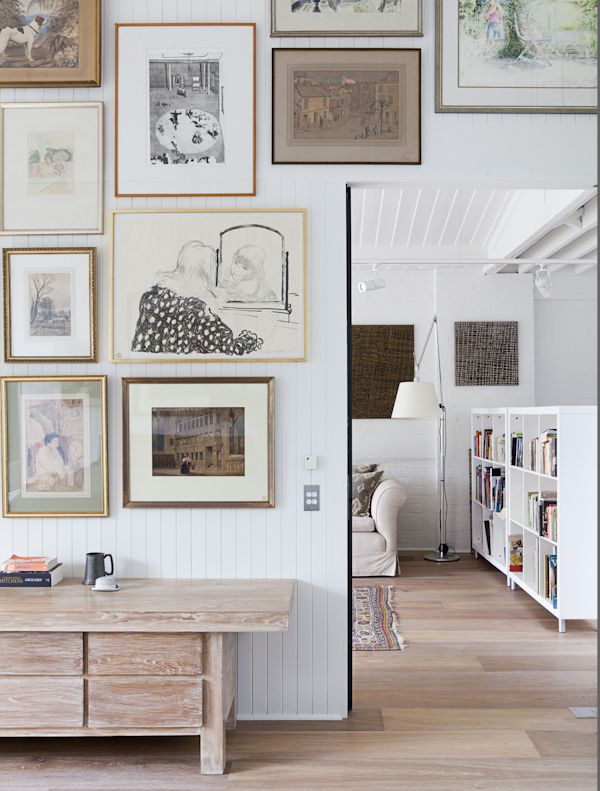 thedesignchaser.com WRAP GALLERY- stagger art work across the wall and around fixed objects like a door frame, T.V., or a large piece of furniture. 