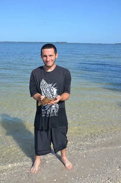 After quite a bit of encouragement from teachers and peers, Richie holds a slimy sea hare for the first time. 