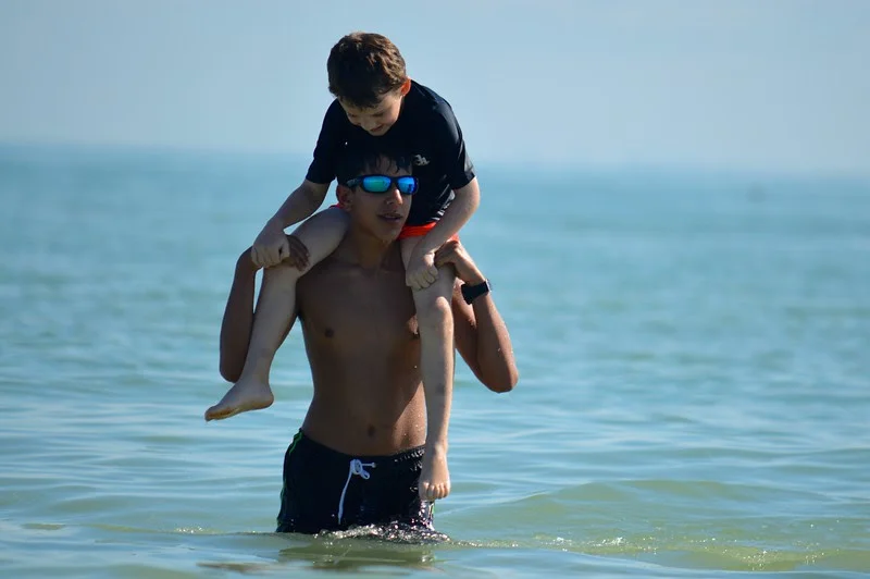 Counselor-In-Training Jivan Khakee gives one of his campers a lift to the beach. 
