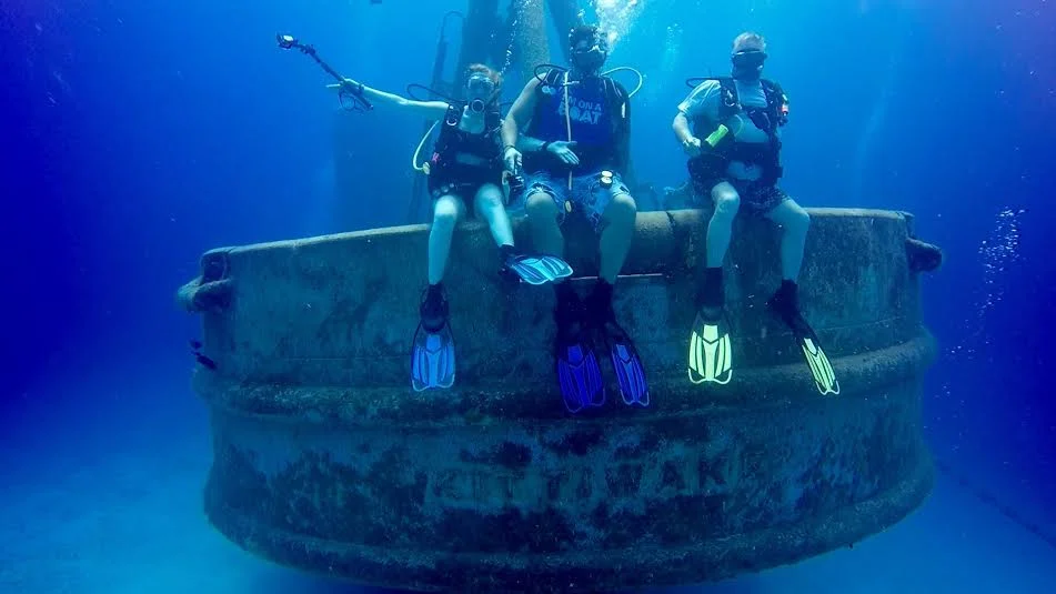 Brooke Linn : Some of my favorite ocean experiences have happened under the surface during my dives in Grand Cayman. Shown here, I am on the stern of the Ex-USS Kittiwake, a former US Navy submarine rescue vessel. On this wreck, I was able to sign one of the very few geocaches underwater! I've also taken lots of Sea Turtle selfies, have been under grottos, gone on night dives and have found octopus that come out to feed, and so much more. I can't wait to finish my Divemaster. 