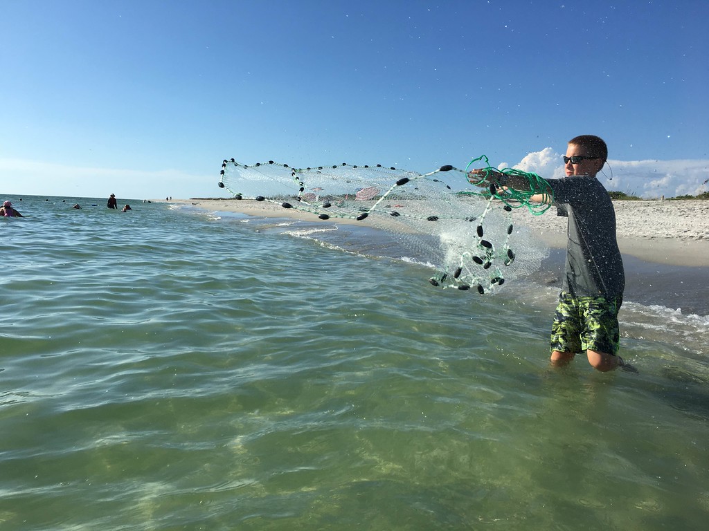 A student practices throwing a cast net during a fishing lesson at Sanibel Sea School.