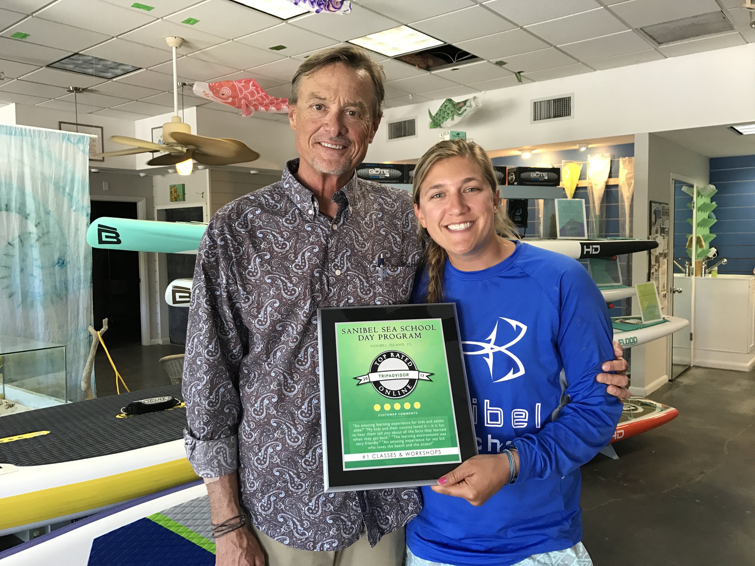 Dr. Bruce Neill, Sanibel Sea School's Executive Director, and marine educator Spencer Richardson pose for a photo with the nonprofit's TripAdvisor award. 