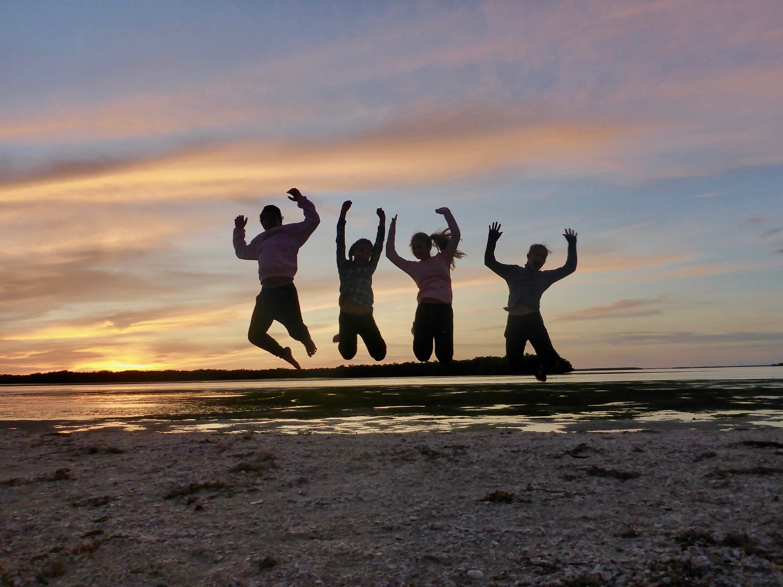 Paddlers jump for joy during a camping expedition to Picnic Island.