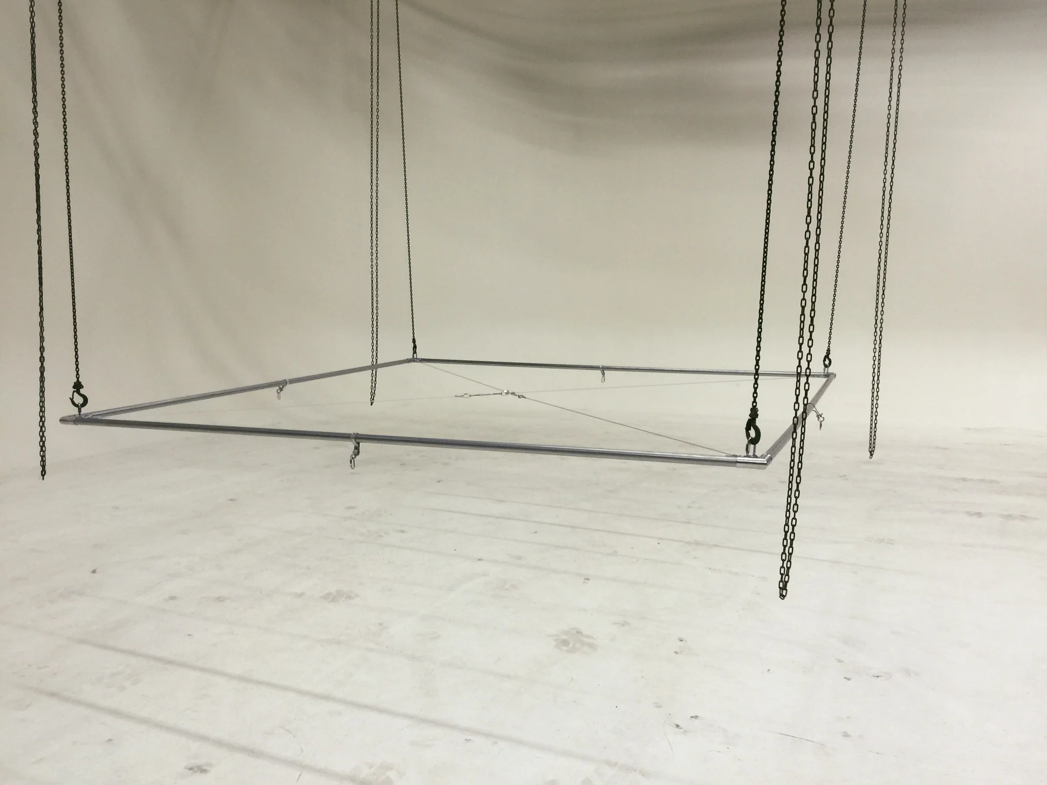The 10' x 10' lighting rig assembled, cross-braced, and hanging from the chains.